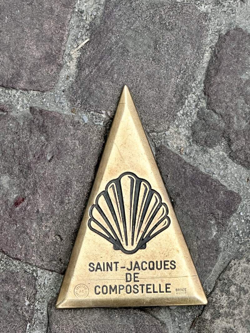 地上的金色三角形貝殼標誌,寫著 SAINT-JACQUES DE COMPOSTELLE