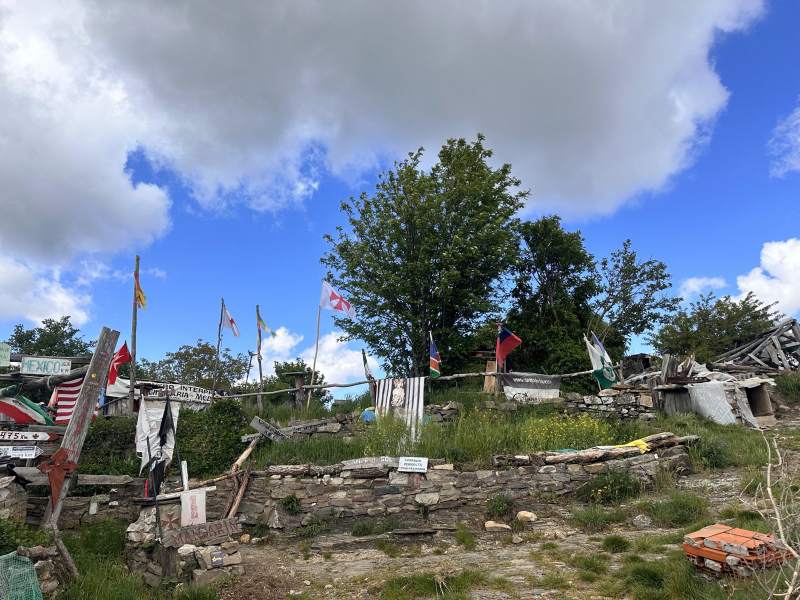 山上掛滿各國國旗和路標的小屋