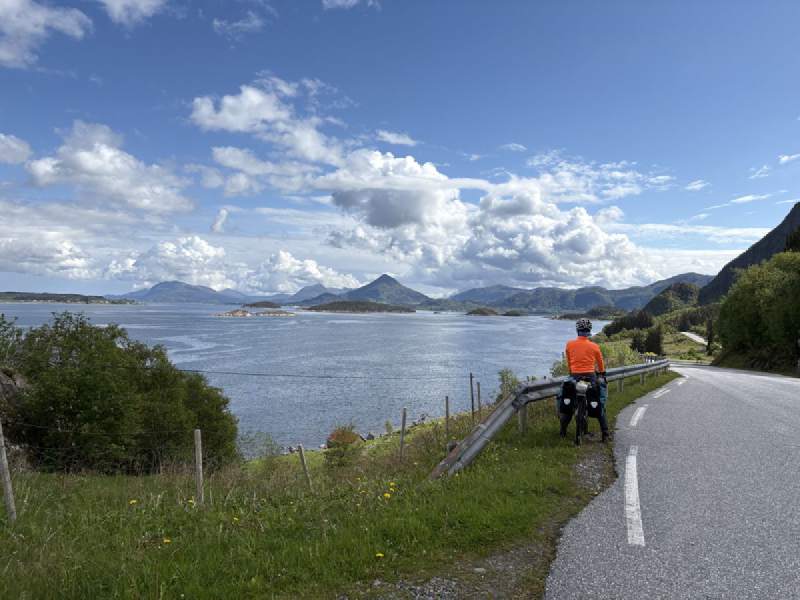 公路邊穿橘色外套的人,遠處是島。