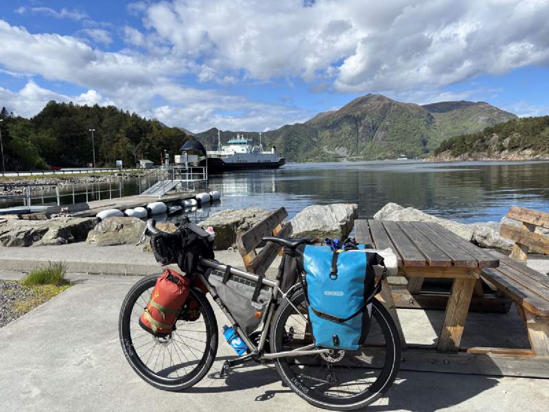 碼頭野餐桌旁的車,海面上一艘渡輪。