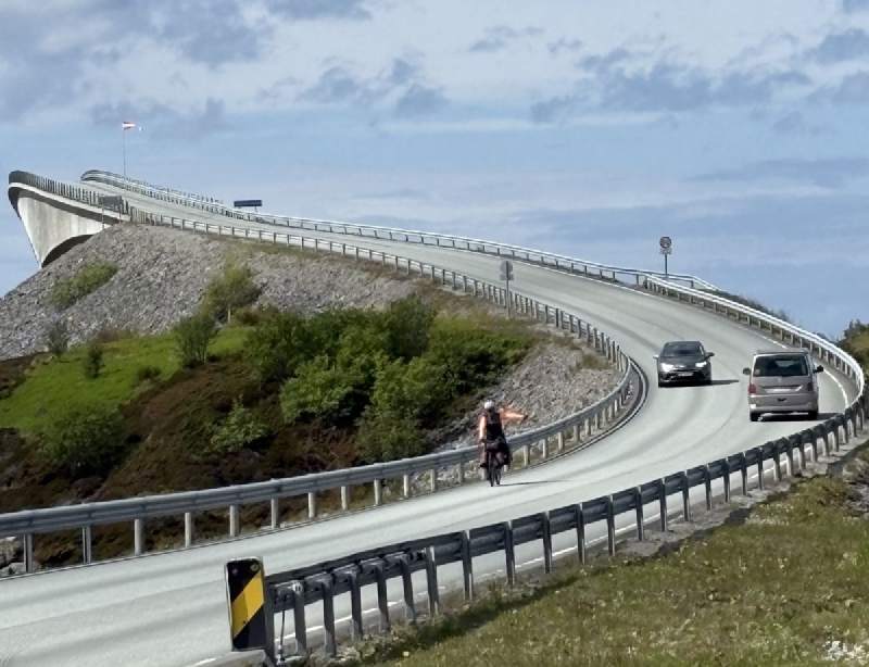 橋的弧線轉過去,有車也有騎車的人。
