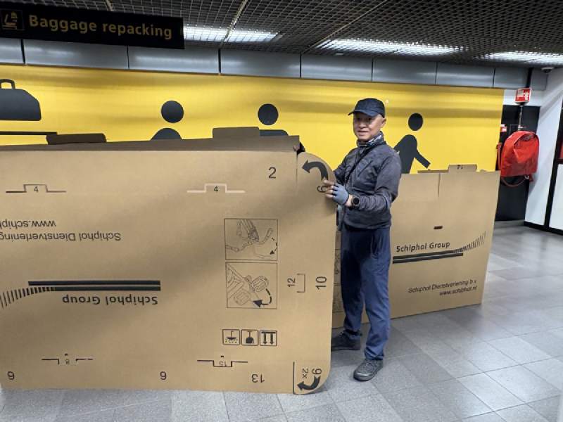 Schiphol 機場的行李打包區,站在一個裝單車的大紙箱旁邊。