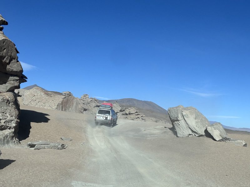 前車揚起的塵,岩石中間那條就是路。