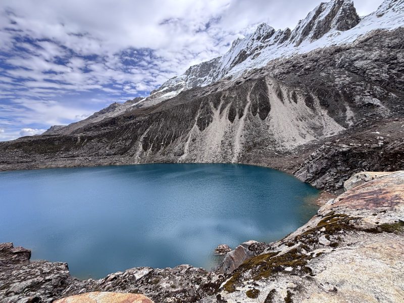 Laguna Congelada:湖水是深的藍綠色,後面整面是碎石坡與雪峰。