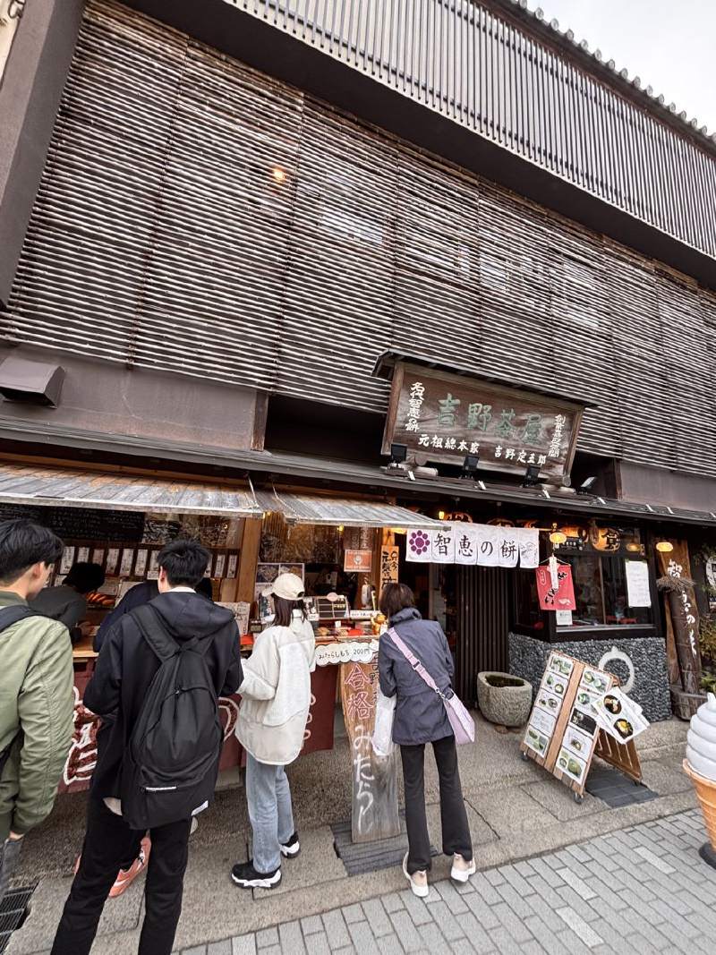 16:39,老式店面,門口站著幾個人在看東西。