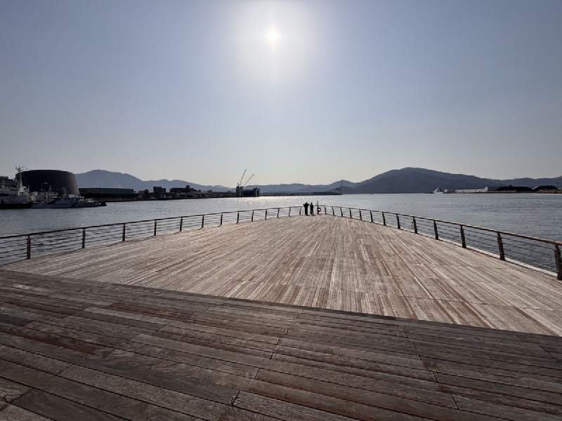 15:19,木頭平台伸向海面,遠處是港口和山。