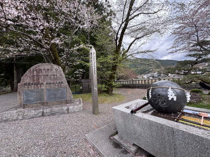 八咫烏的石球、刻字的石碑,櫻花在後面安安靜靜地開。