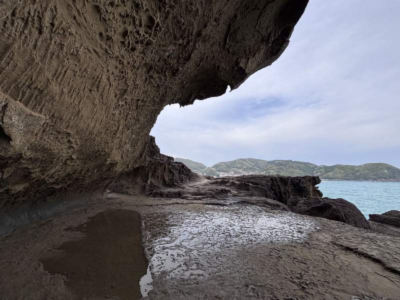 岩洞像一隻張開的嘴,把遠山和海,一口含住。