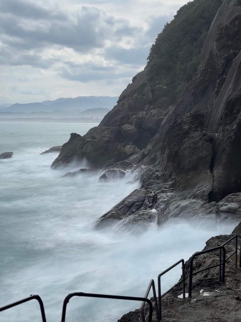 15:47,浪一波一波打上鬼城的岩岸,遠處一道海岸線在霧裡。