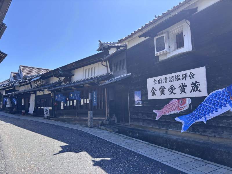 09:14,中津川宿的酒藏,黑木板牆上釘著「全国清酒鑑評会 金賞受賞蔵」,底下飄著兩條鯉魚。