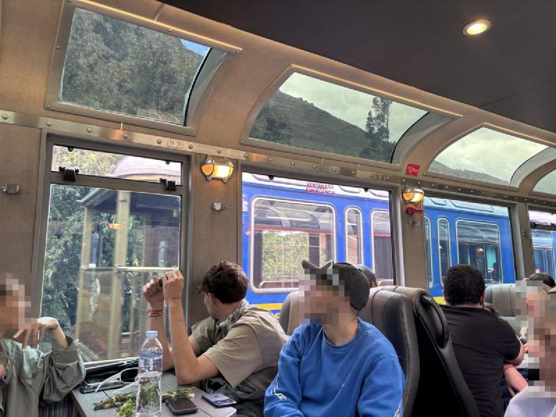 12:46,景觀車廂,頂上和側面都是玻璃窗,旅客坐在桌邊。